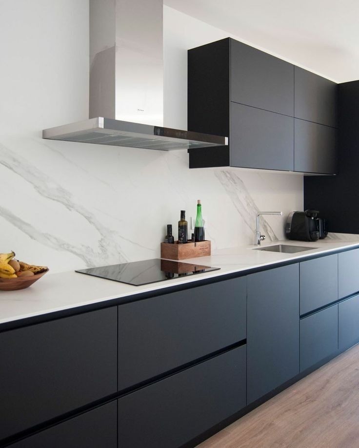 Modern black matte kitchen cabinets with white marble backsplash design