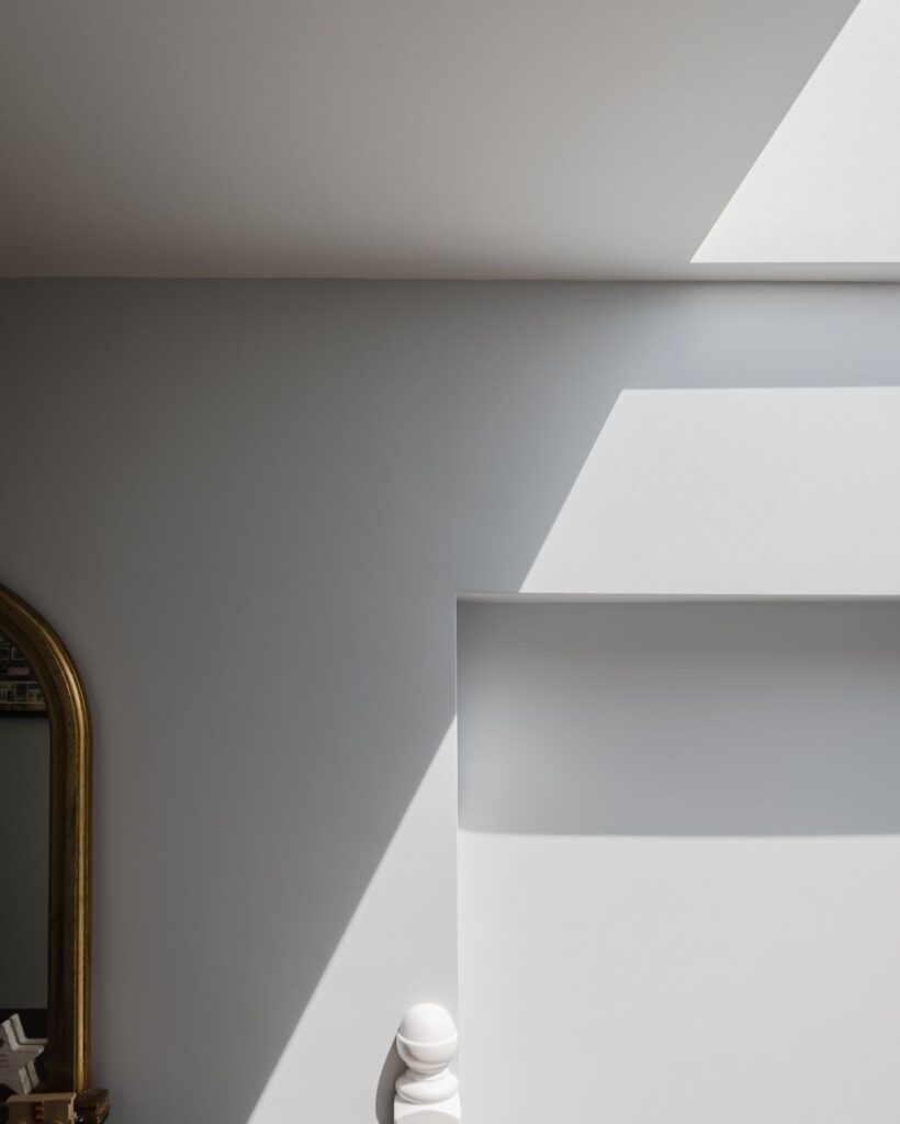 Natural sunlight streaming through skylight onto modern white wall