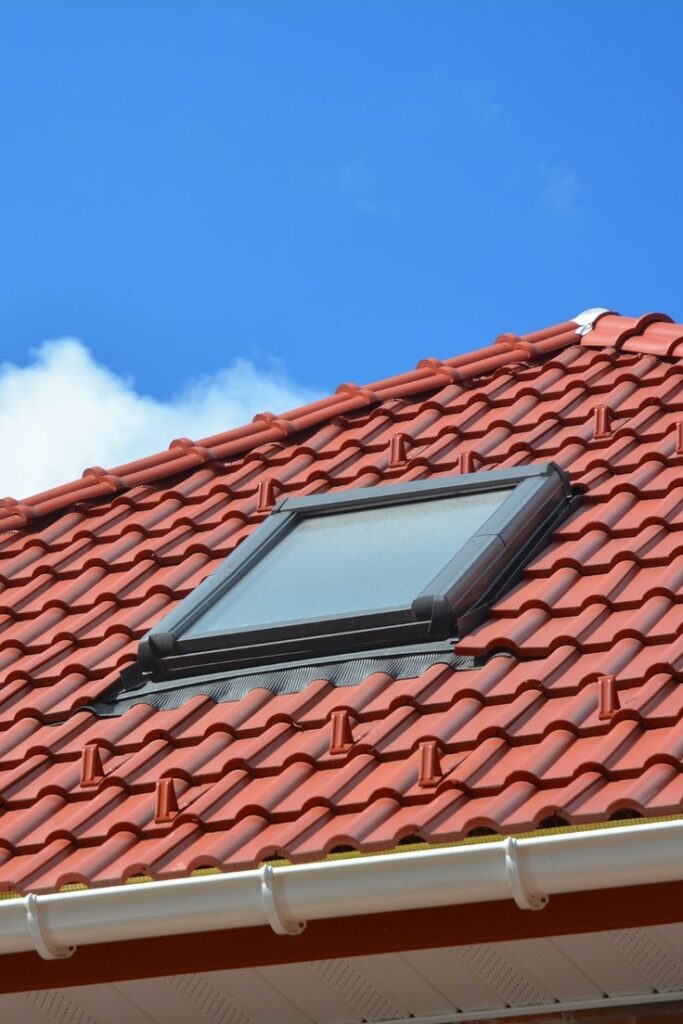 Roof skylight window on red clay tile roof