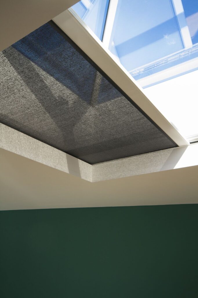 Skylight window with retractable blackout shade and sunlight view