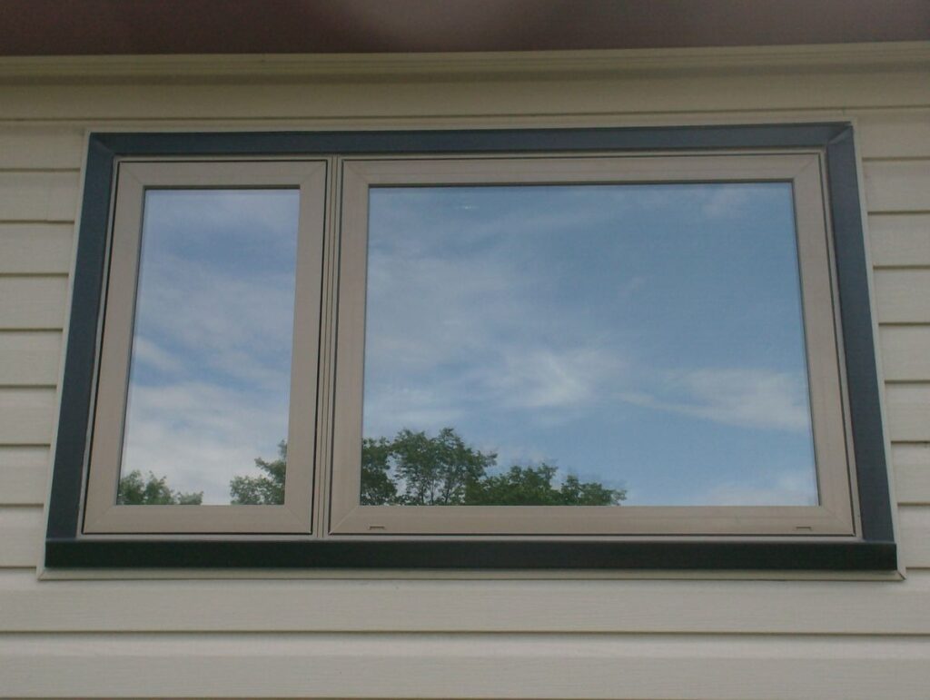 Modern double-pane casement windows on beige vinyl siding