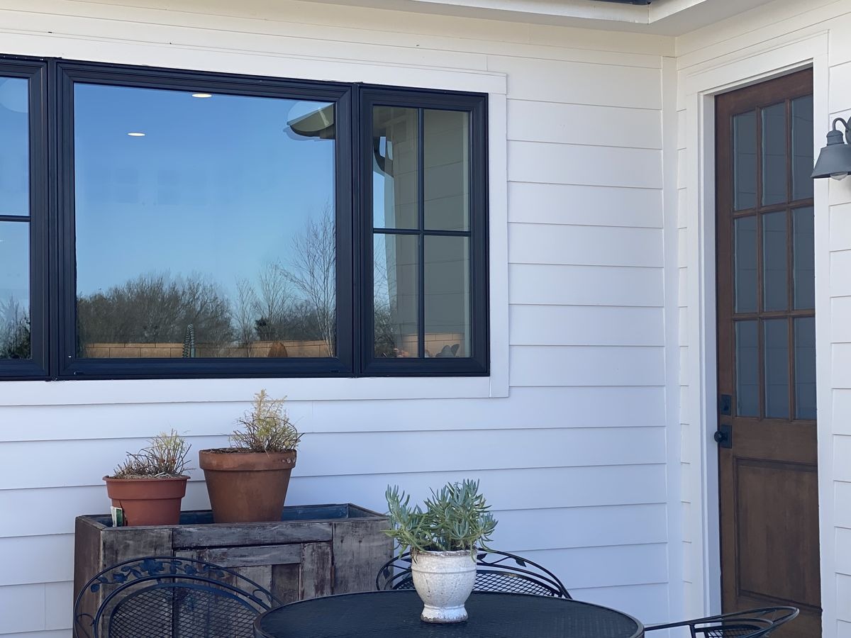Black frame windows on white siding farmhouse style exterior