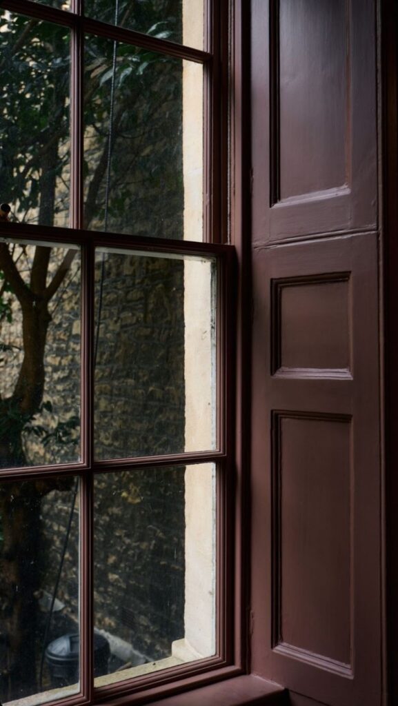 Classic wooden sash window with dark brown painted frame