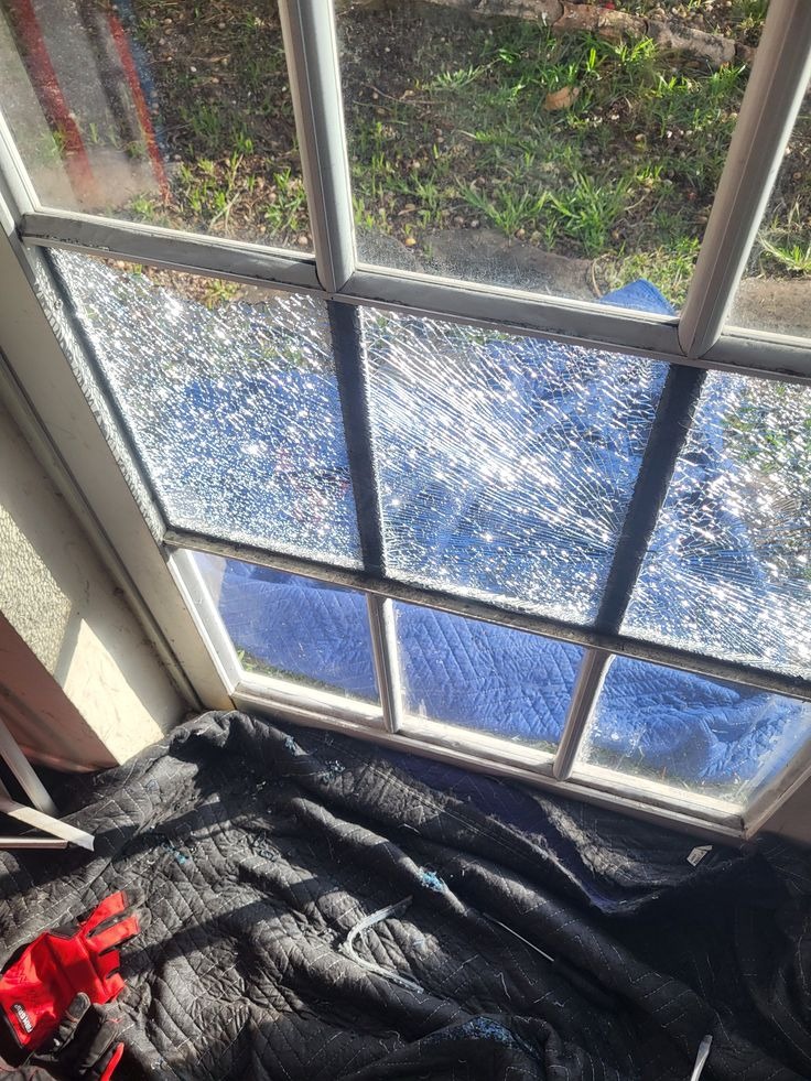 Broken window pane with shattered tempered glass needing repair