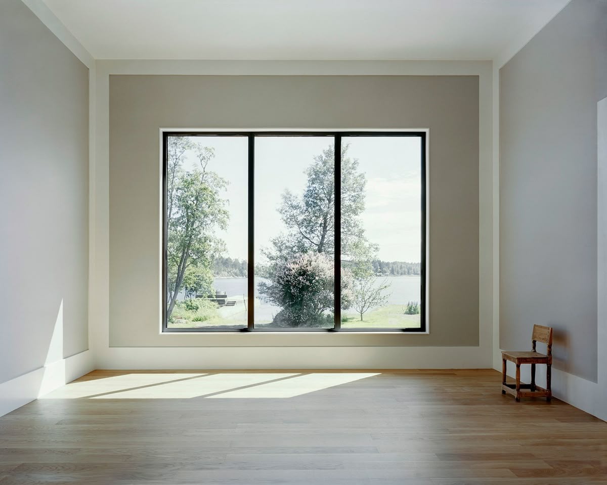 Large picture window overlooking lake and green landscape view